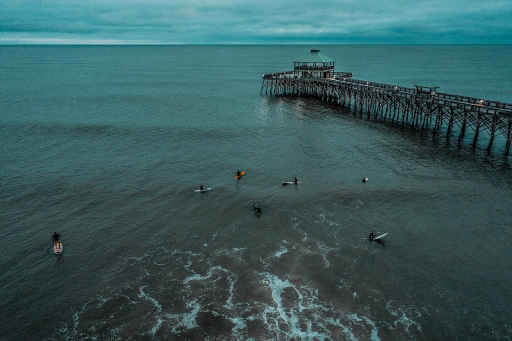 Surfers at the beach near the pier in Folly Beach, SC